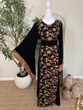The Midnight Garden Abaya featuring intricate floral embroidery in warm tones on a black base with wide bell sleeves and detailed cuffs, displayed on a mannequin.