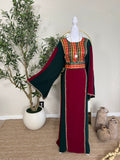 The Sultana Thoub featuring traditional Palestinian embroidery on a rich burgundy and dark green fabric with wide flowing sleeves, elegant and handcrafted modest fashion dress.