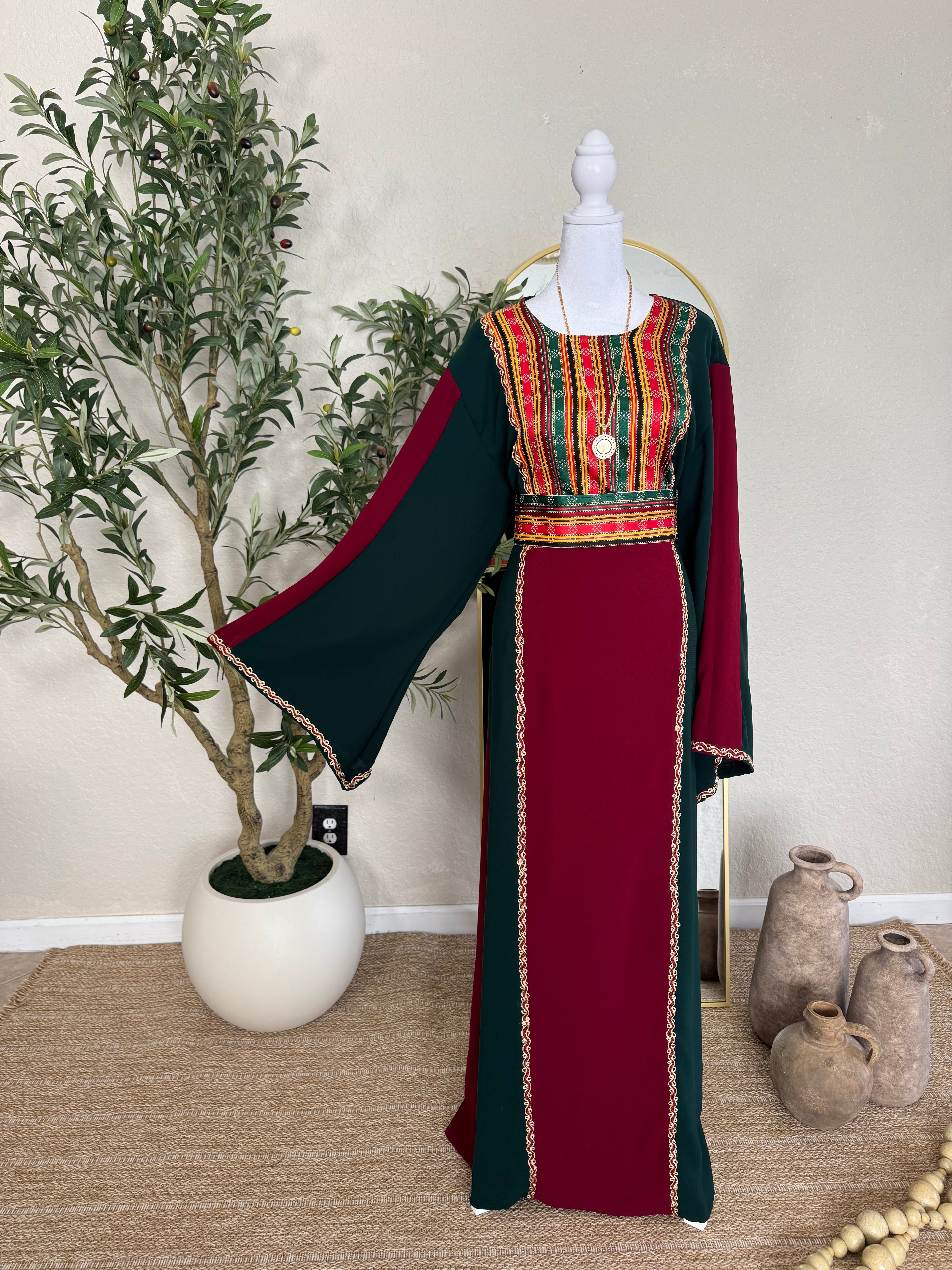 The Sultana Thoub featuring traditional Palestinian embroidery on a rich burgundy and dark green fabric with wide flowing sleeves, elegant and handcrafted modest fashion dress.