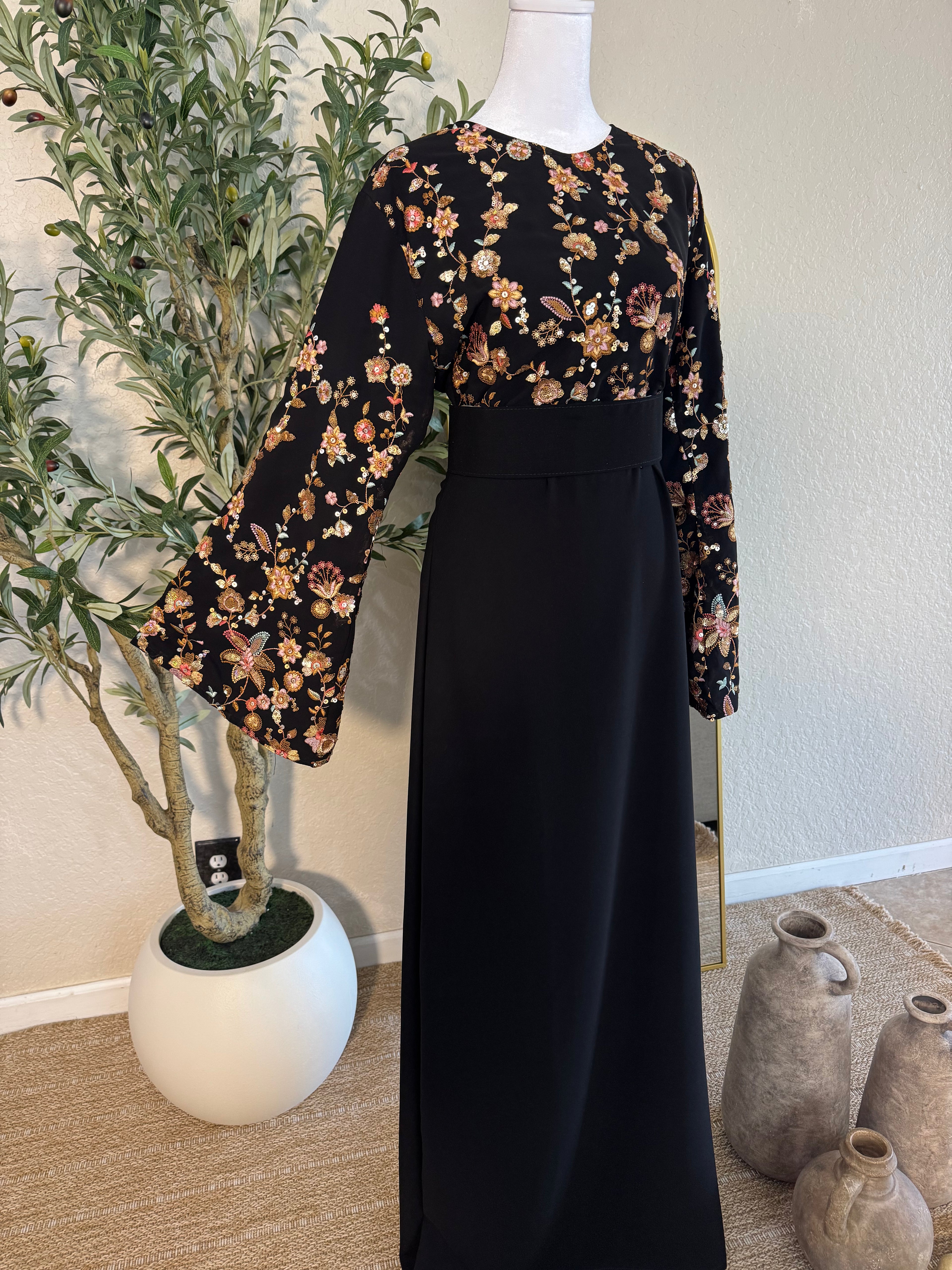 Elegant black modest dress with floral embroidered sleeves and flowing silhouette