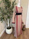 Front view of The Ramallah Line Palestinian Abaya in dusty taupe with red geometric vertical detailing and black waist belt