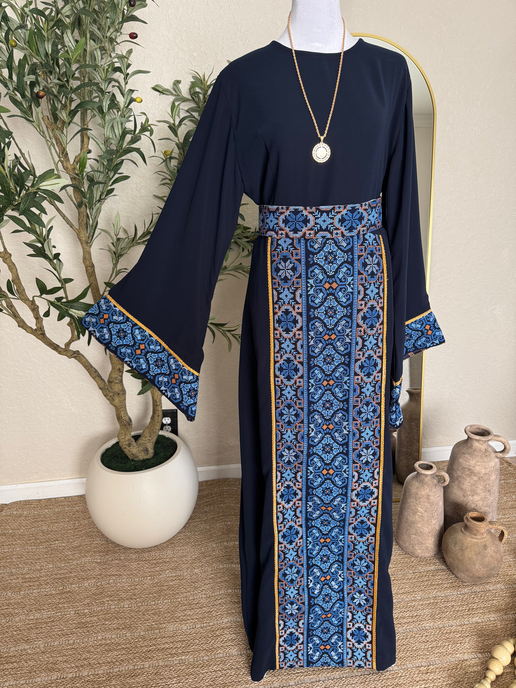 The Azraq Thoub navy modest dress with blue Palestinian inspired embroidery and flowing sleeves