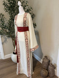Close-up of The: Bethlehem Sand Thobe featuring an ivory base, terracotta heritage-inspired trim, wide sleeve and rust-red waist belt