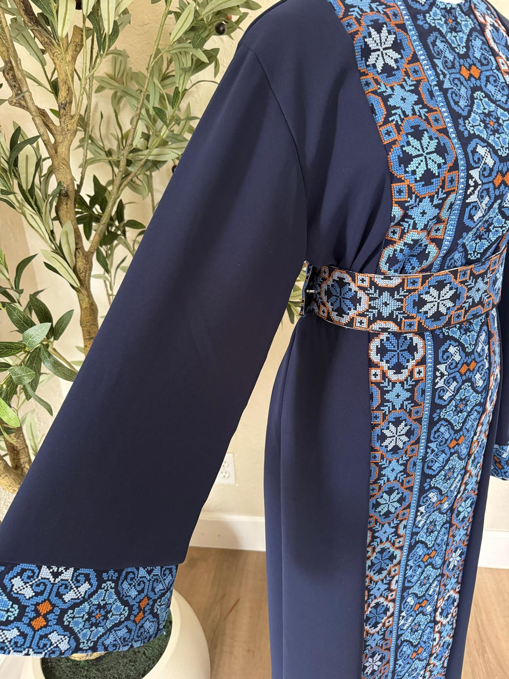 Close-up of The Cobalt Heritage Thobe with blue geometric patterned cuff and gold-toned trim