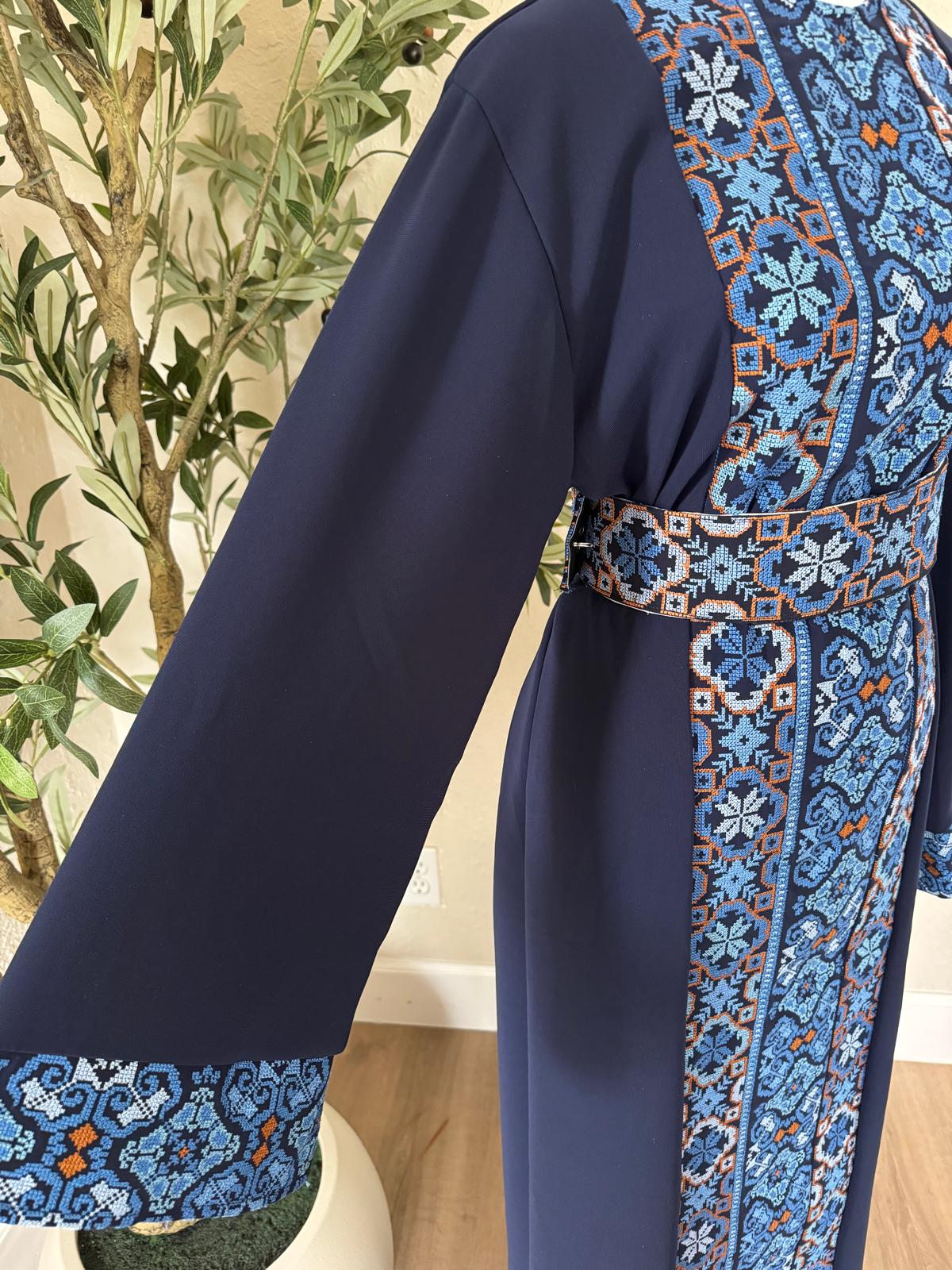 Close-up of The Cobalt Heritage Thobe with blue geometric patterned cuff and gold-toned trim