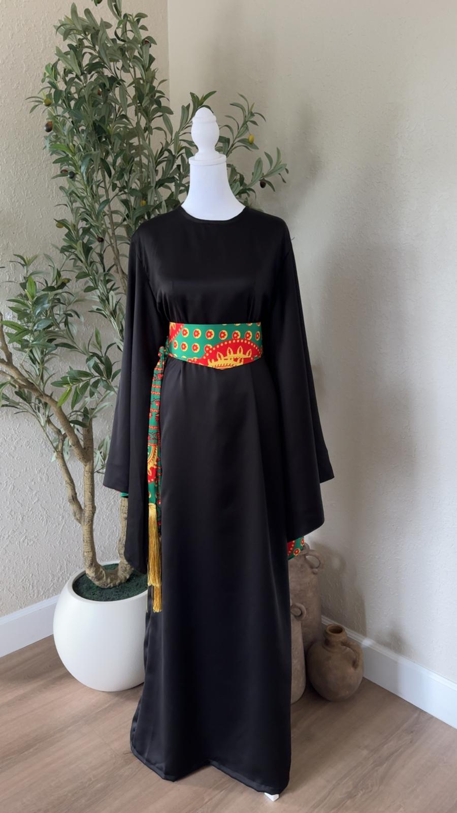 The Saffron Sash Dress in black with patterned waist sash and golden tassel details