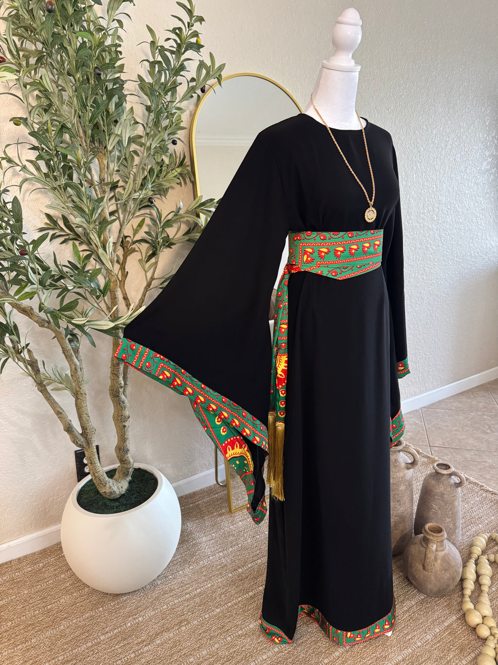 Black traditional Asba abaya with green and red embroidered trim and matching belt